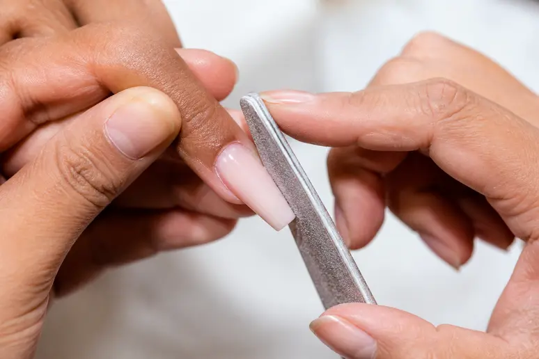 Façonnage précis d'un ongle coffin en gel au chablon par une professionnelle.