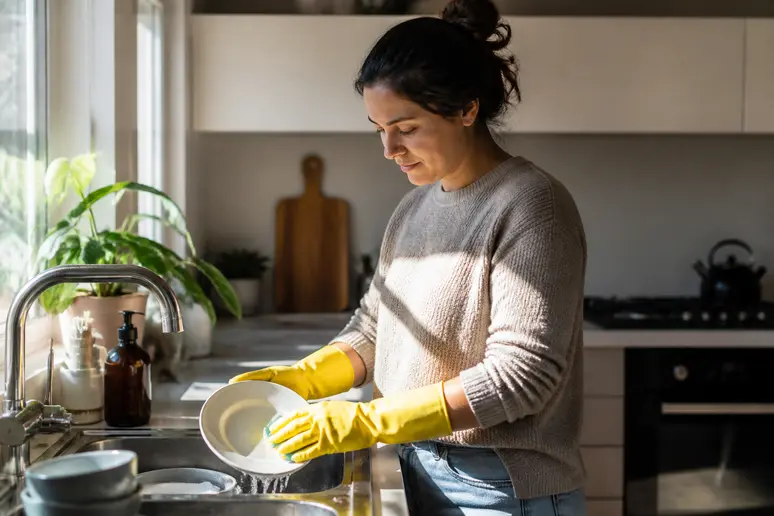 Port de gants pour protéger les mains et prévenir l'onycholyse lors des tâches ménagères.