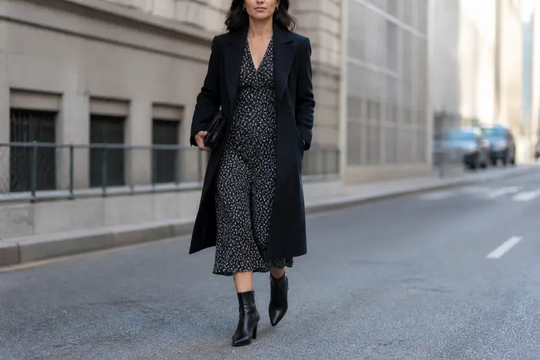 Femme portant une robe midi et des bottines noires pour harmoniser sa silhouette.
