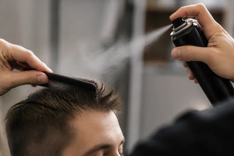 Mains crêpant les racines des cheveux courts avec un peigne fin avant la coiffure