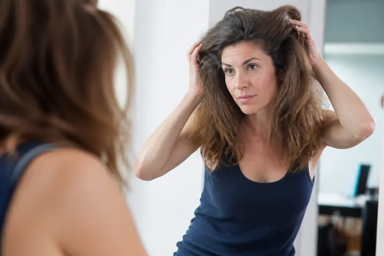 Femme observant la largeur et le volume de sa coupe femme cheveux épais après le séchage