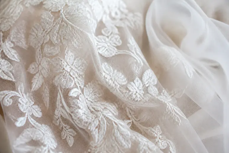 Détail de dentelle et de tulle souple sur une robe de mariée romantique