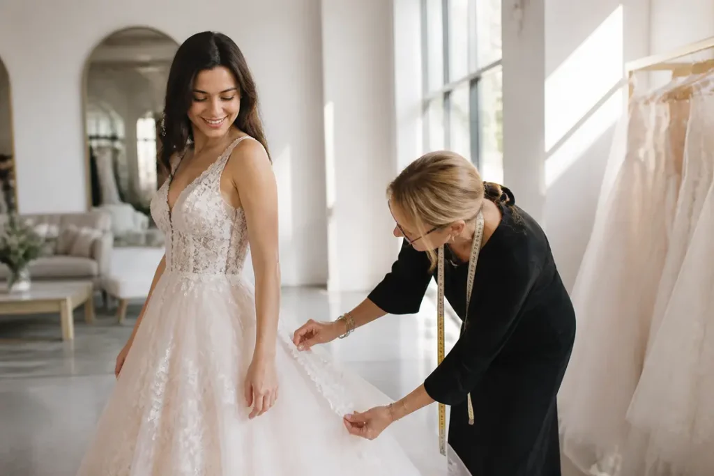 Une future mariée essayant une robe de mariée romantique dans un atelier lumineux