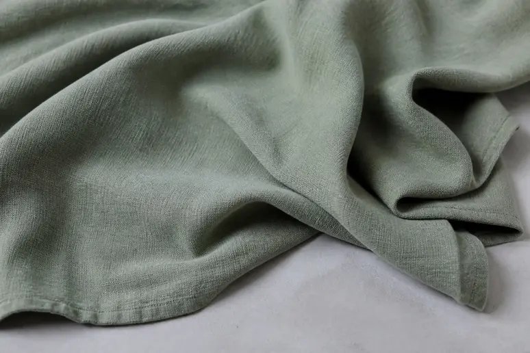 Nuances et sous-tons argentés d'un tissu de robe invitée mariage vert sauge