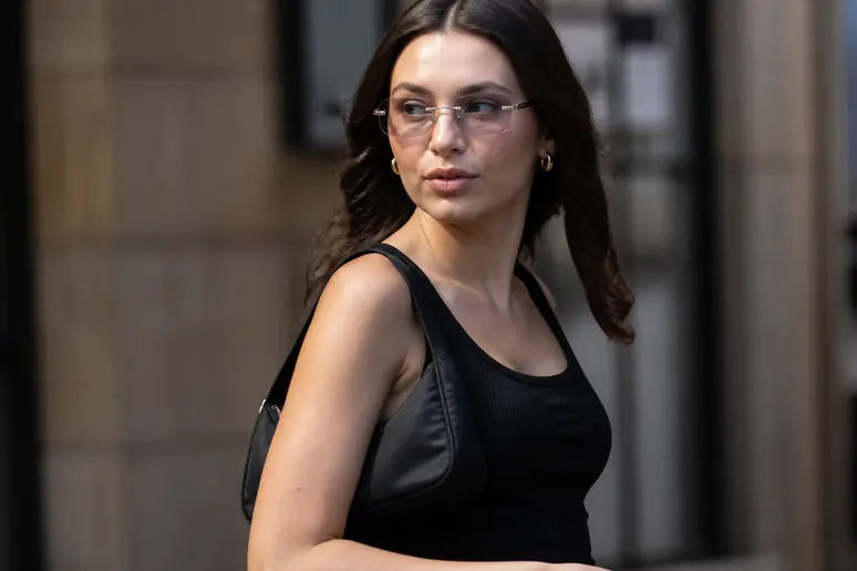 Détail d'une tenue style Y2K femme avec un mini sac baguette et des lunettes teintées