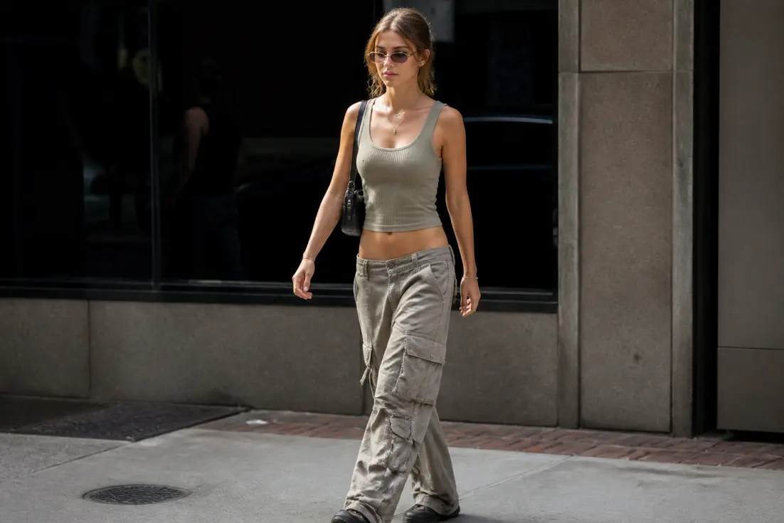 Jeune femme élégante portant des vêtements inspirés du style Y2K femme dans une rue urbaine lumineuse