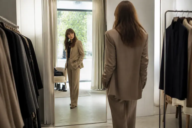 Essayage de plusieurs tenues d'anniversaire devant un miroir pour vérifier l'équilibre des volumes.