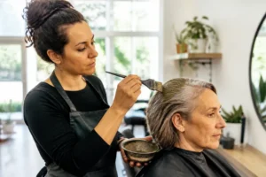 Cliente en salón de belleza probándose una quelle coloration cheveux blancs natural sin productos químicos