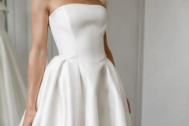 Gros plan sur la coupe structurée et le tissu en mikado d'une robe de mariée ivoire