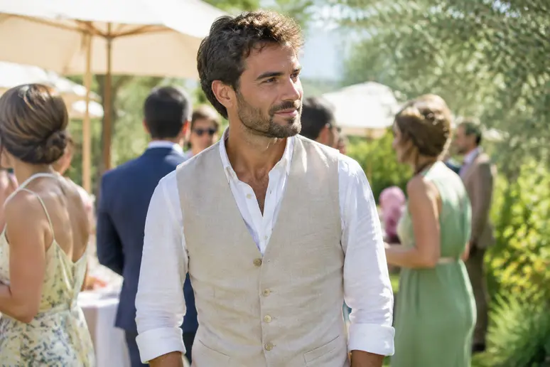 Invité à un mariage habillé d'une chemise en lin et d'un gilet dans un esprit bohème chic.