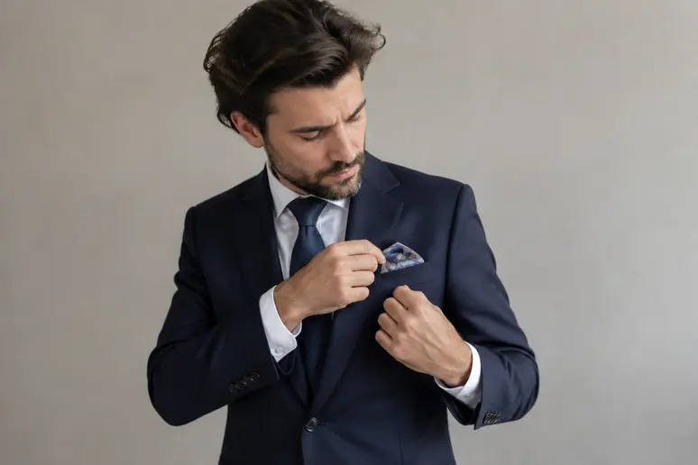 Pochette en soie blanche soigneusement ajustée sur une veste pour un style classique homme