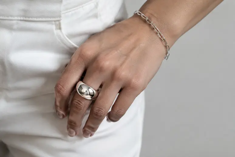 Bague large en argent et chaîne courte pour composer un style rock femme élégant.